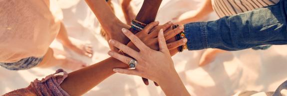 Team hält Hände in der Mitte zusammen