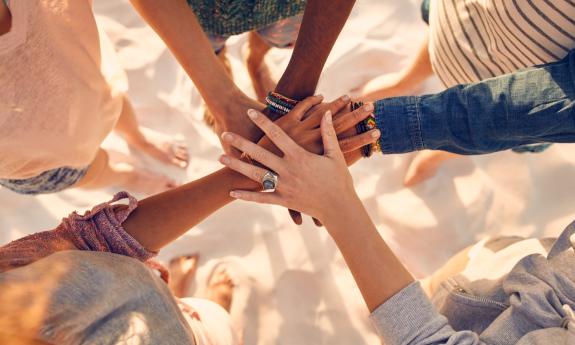 Team hält Hände in der Mitte zusammen